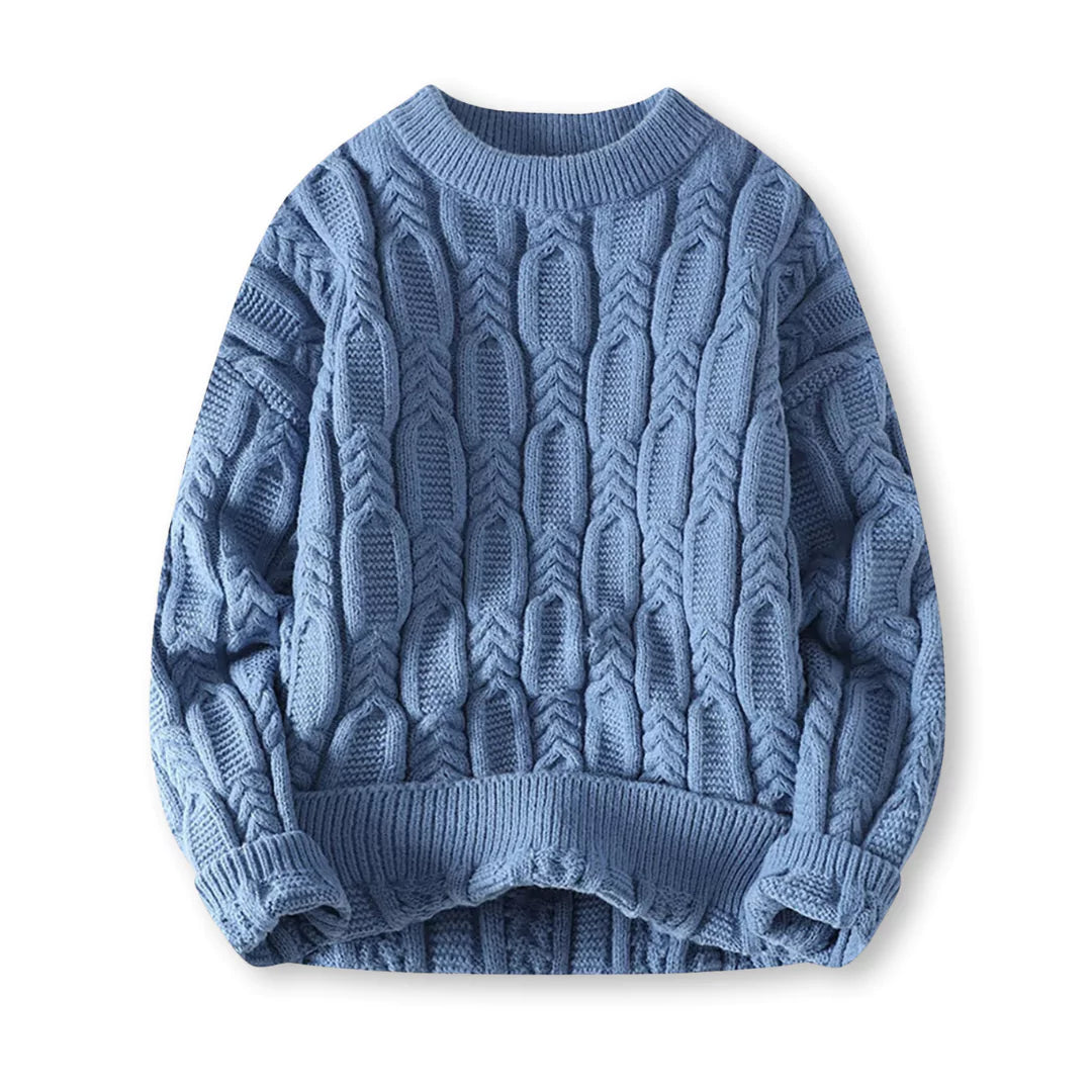 Flat-lay of blue braided cable sweater on a white background
