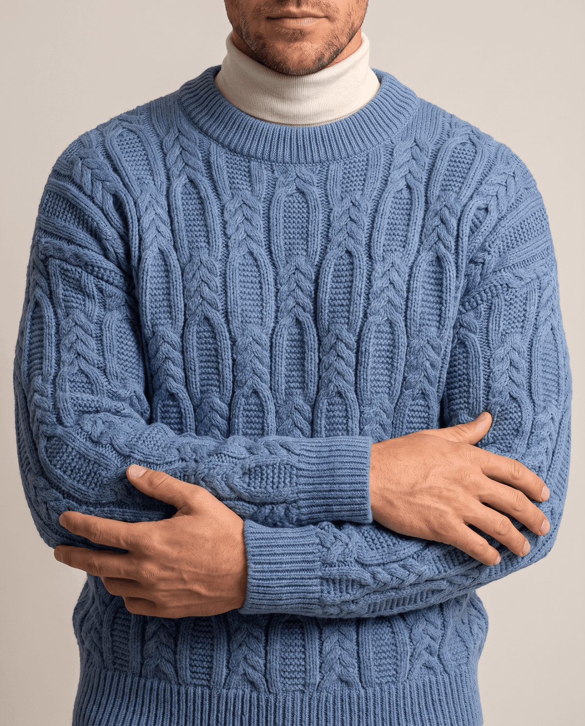 Blue braided cable knit worn over beige mock neck, front close-up