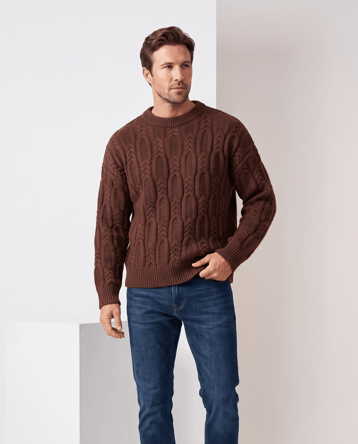 Model in brown crew neck cable sweater with blue jeans