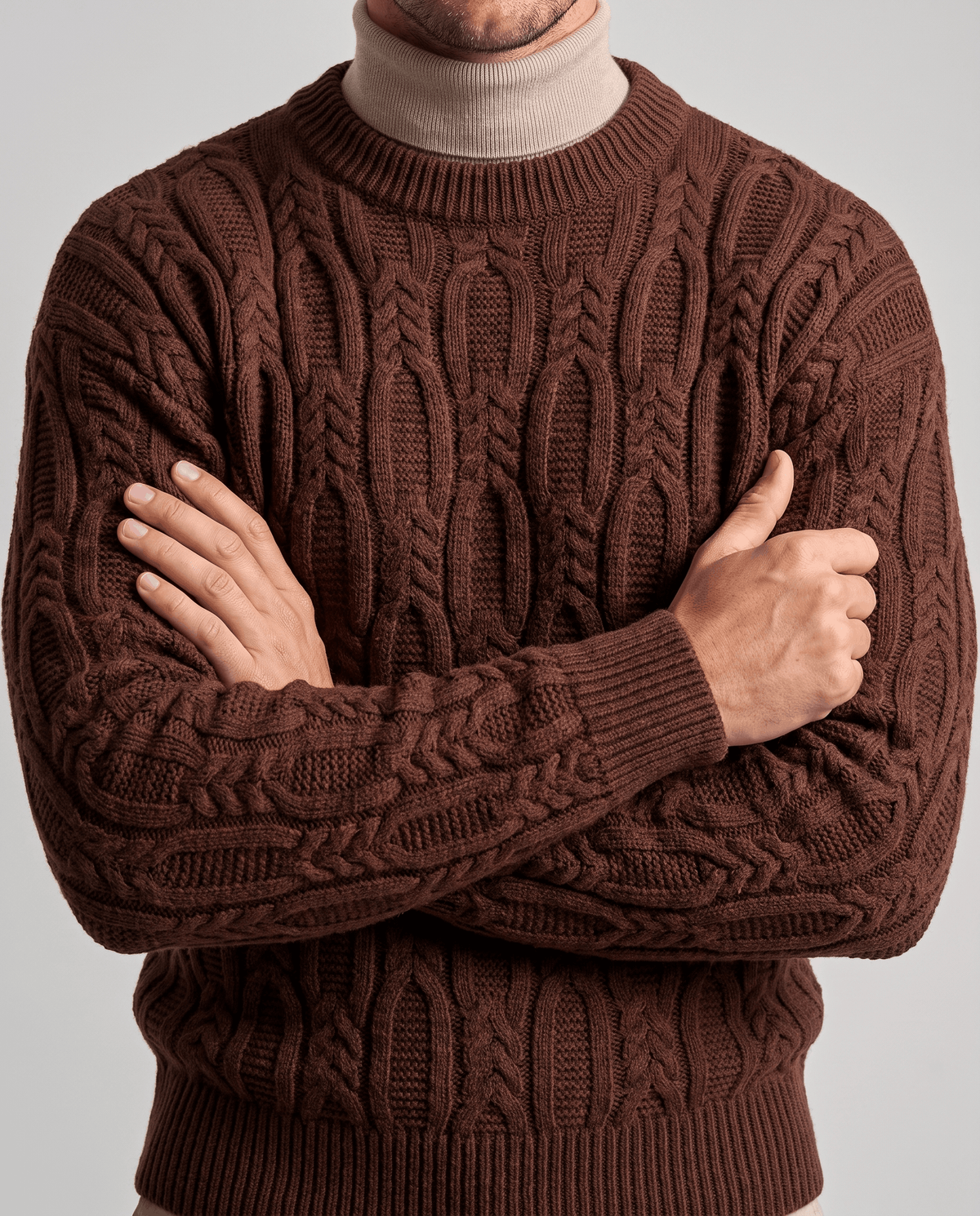 Brown braided knit over beige mock neck with arms crossed
