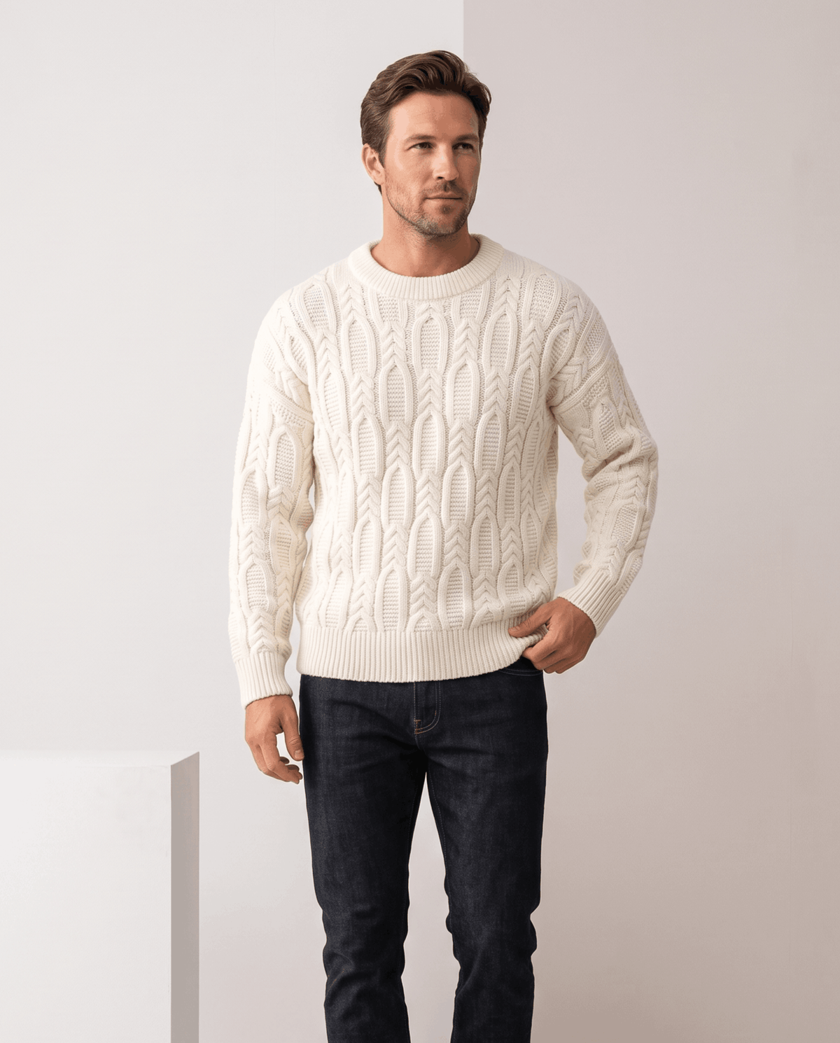 Model in cream crew neck cable sweater with dark jeans