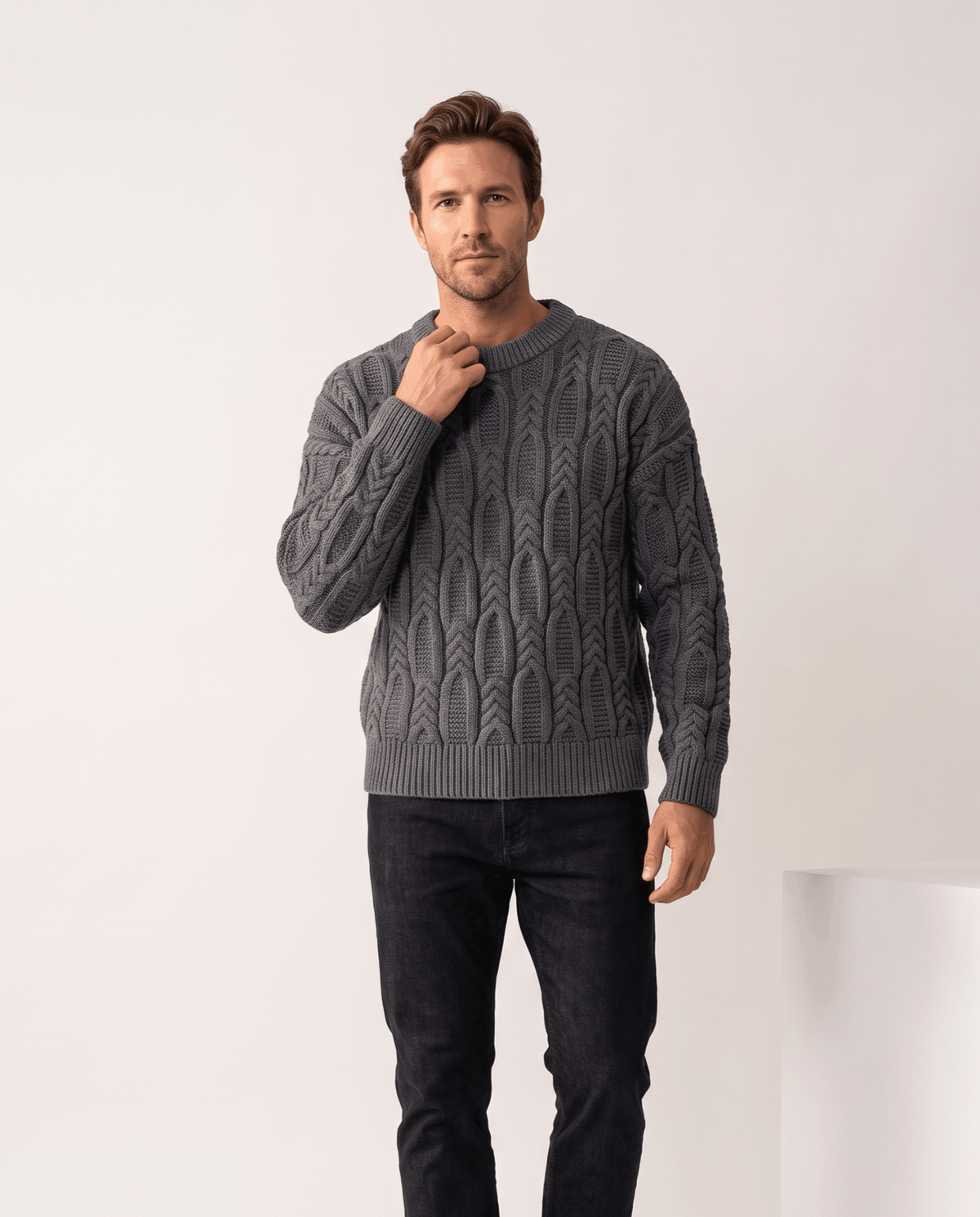 Model in charcoal gray crew neck cable sweater with black jeans