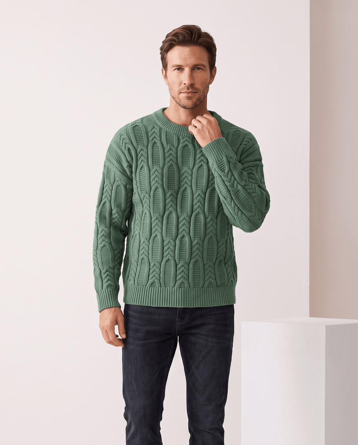 Man wearing men's braided cable-knit crew neck sweater in green with black jeans