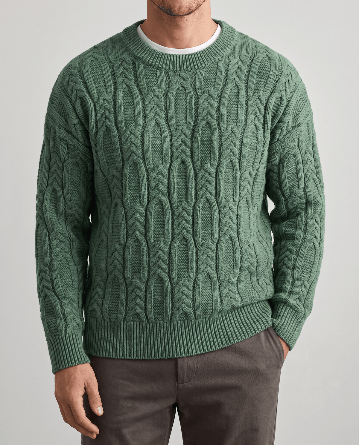 Front close-up of green braided cable knit layered over a white tee