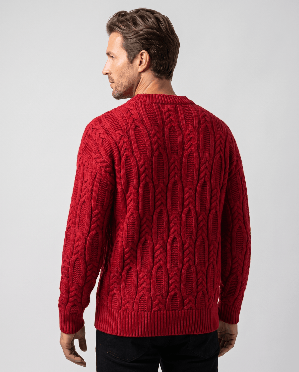 Back view of red cable pullover with ribbed hem and black trousers