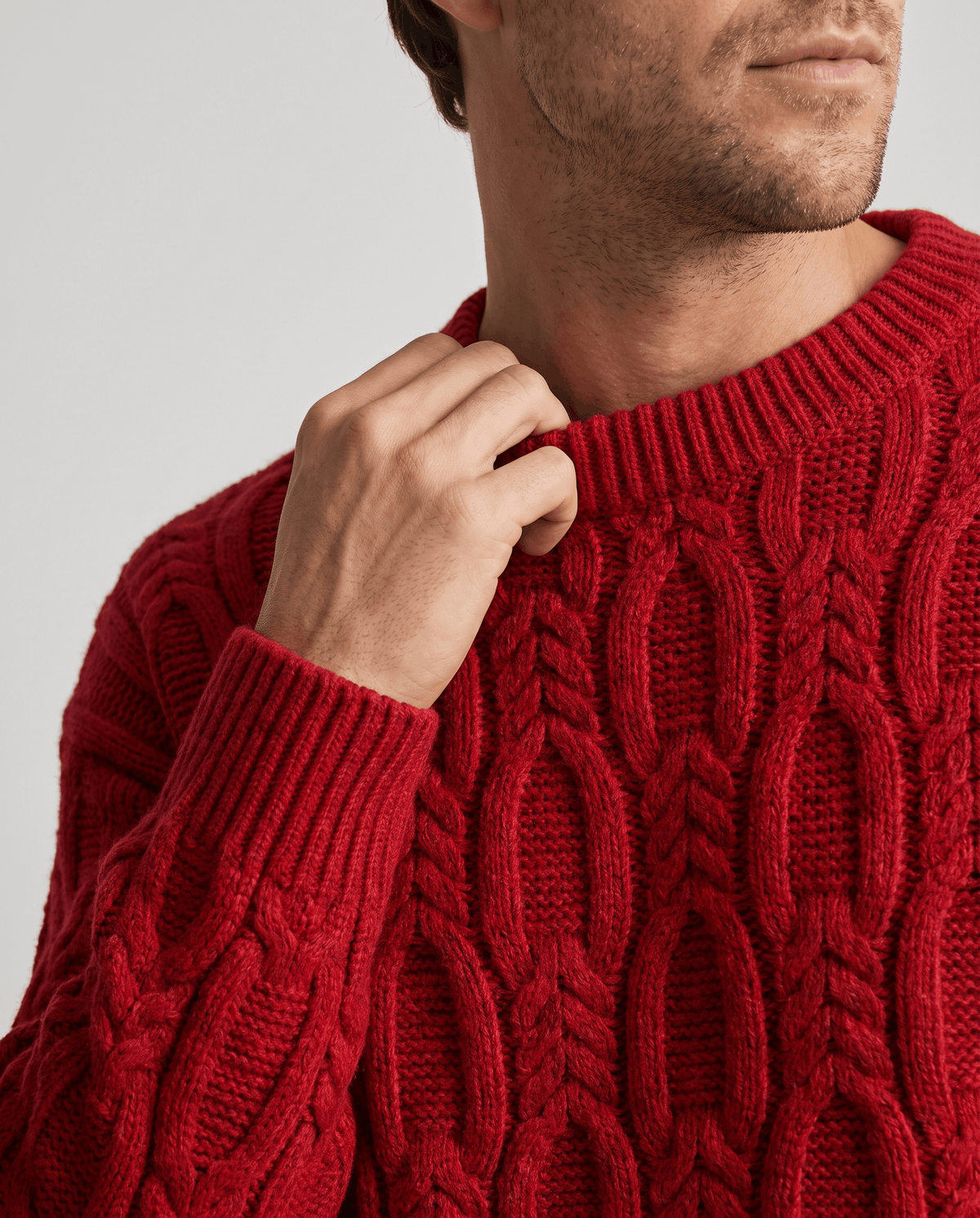 Close-up of hand at the ribbed collar of a red chunky knit