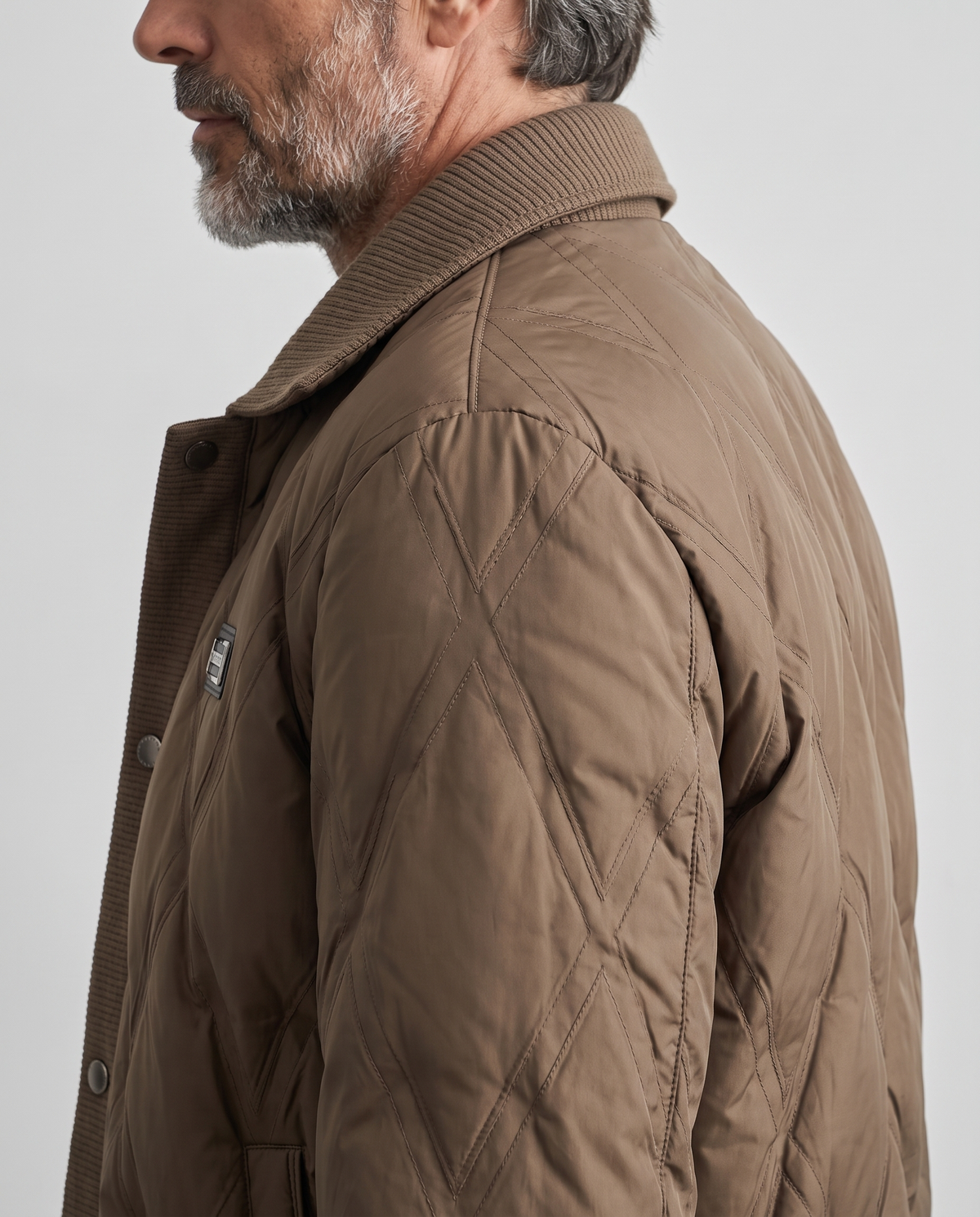 Close-up of the diamond quilting on the shoulder of a brown puffer jacket