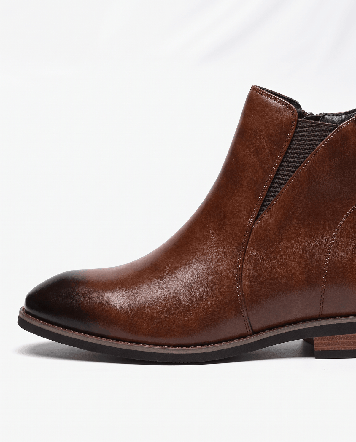 Close-up of a brown Chelsea boot with elastic side panel and smooth upper