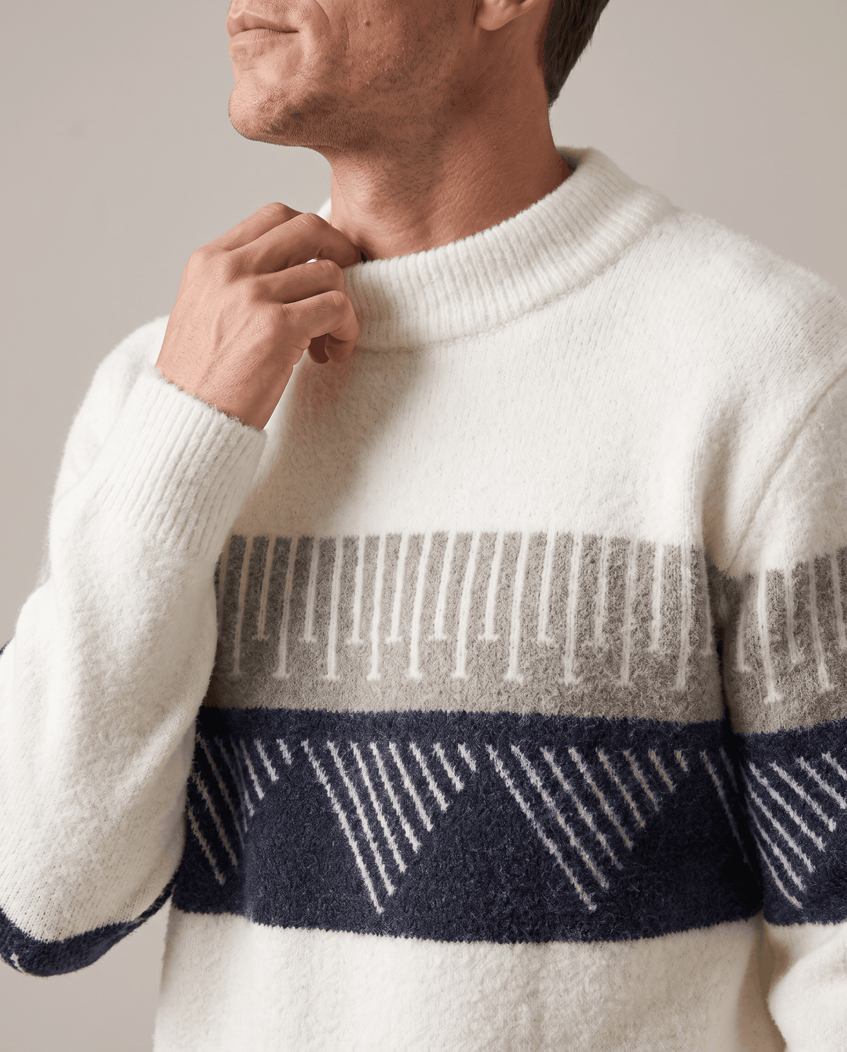 Close-up of hand at the high ribbed crew collar of a white brushed knit