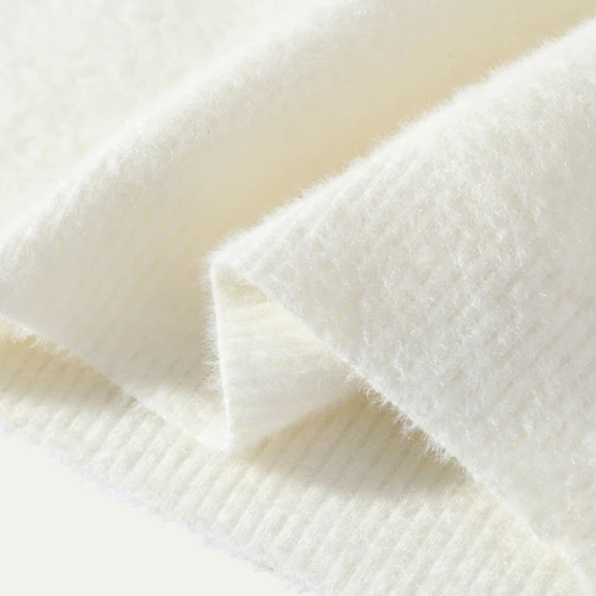 Close-up of soft white brushed knit fabric and ribbed hem