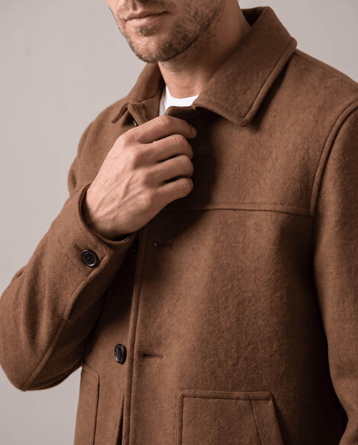 Camel jacket detail showing the tonal buttons and a hip patch pocket