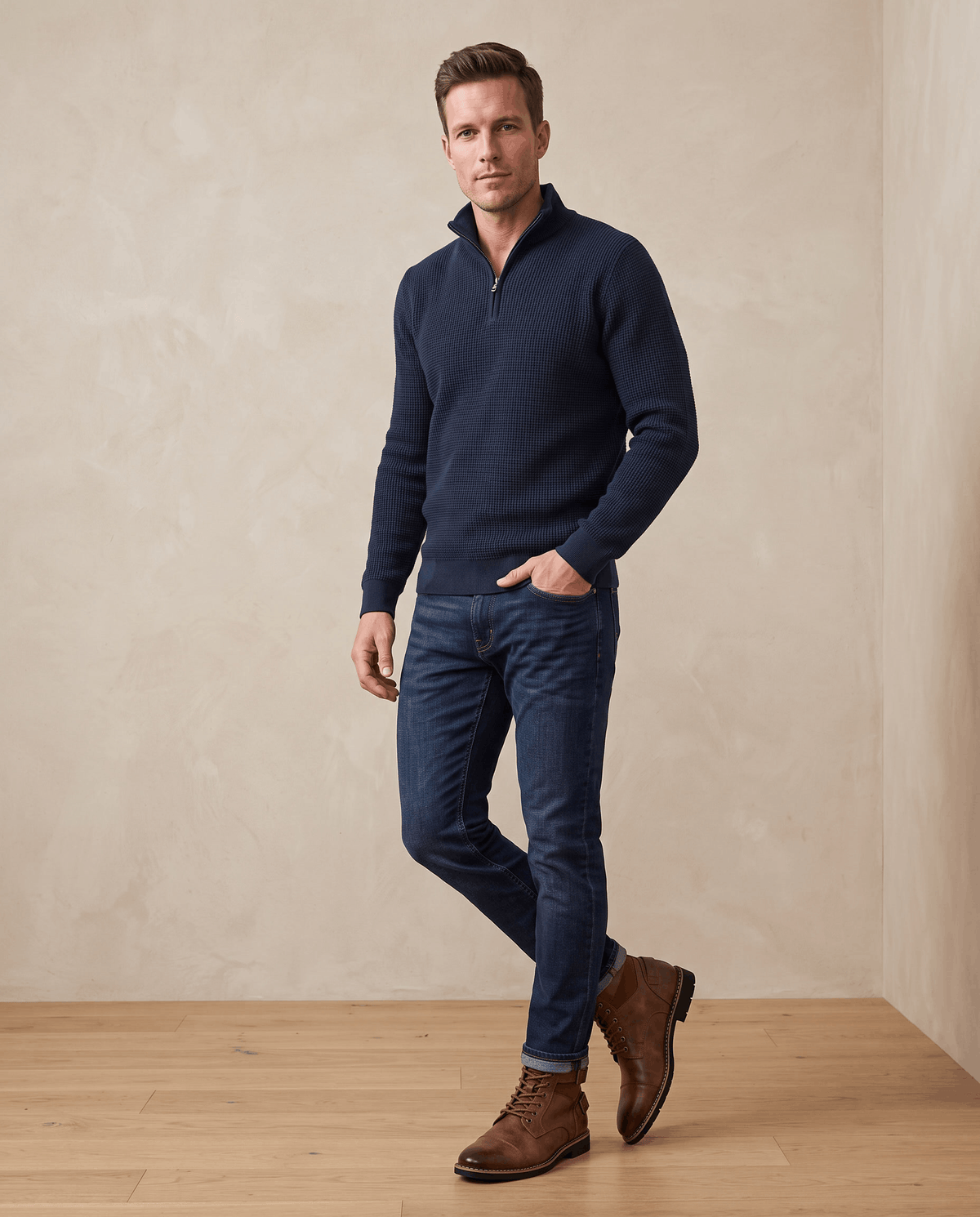 Brown leather lace-up buckle boots with layered panels, cap toe, and stacked heel worn with dark denim jeans.