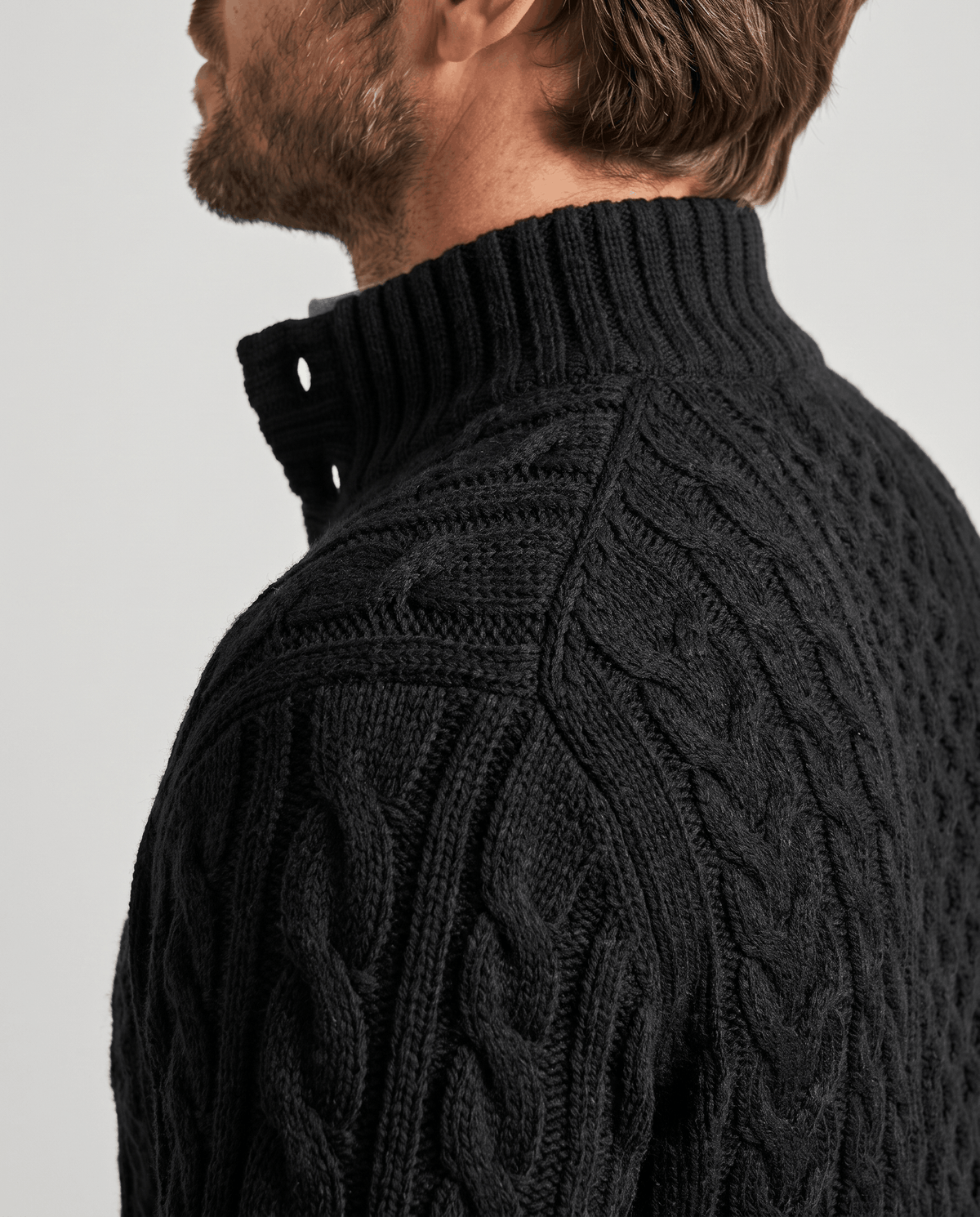 Side close-up of black ribbed stand collar with button fastening