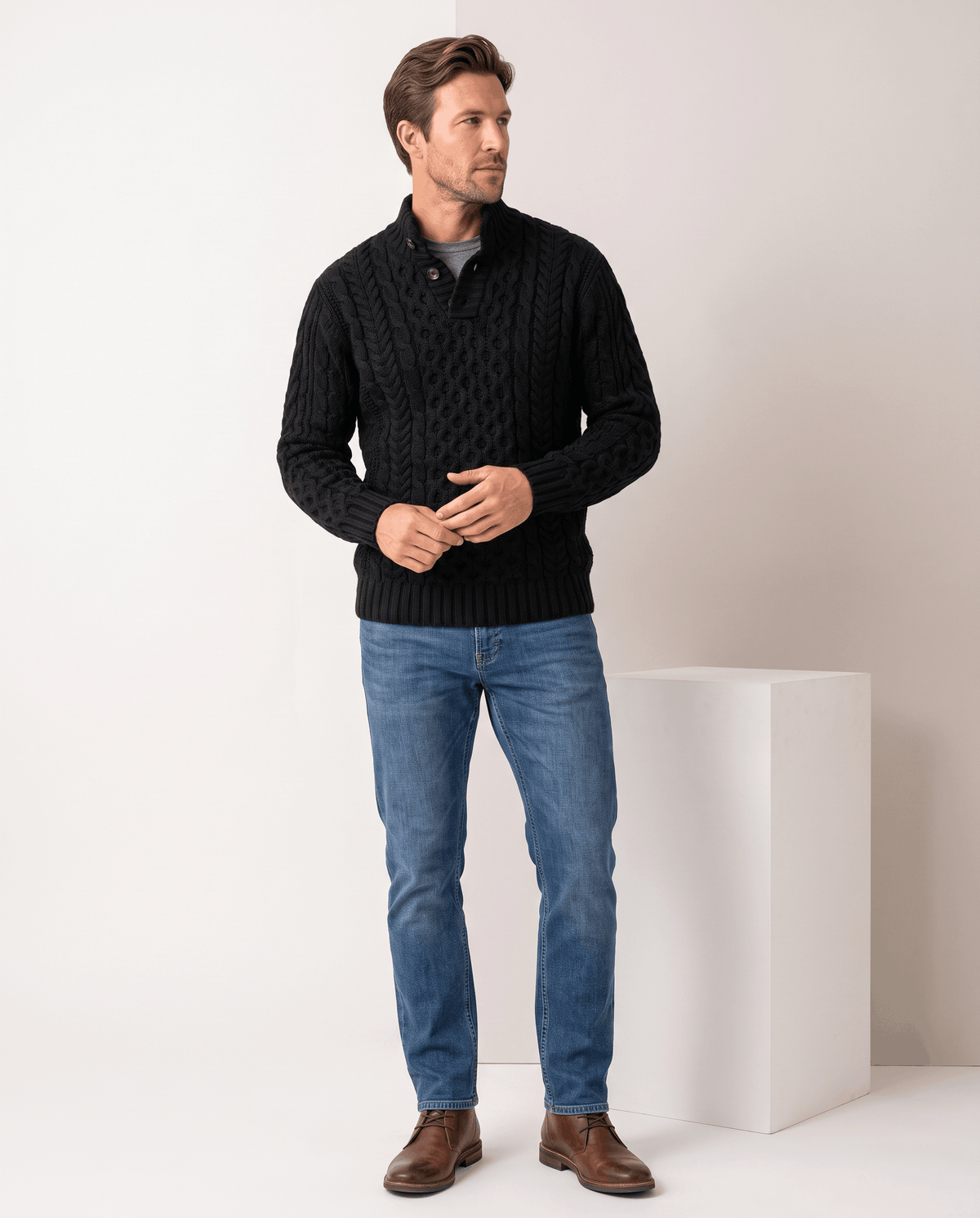 Full-length black cable sweater look with jeans and brown boots