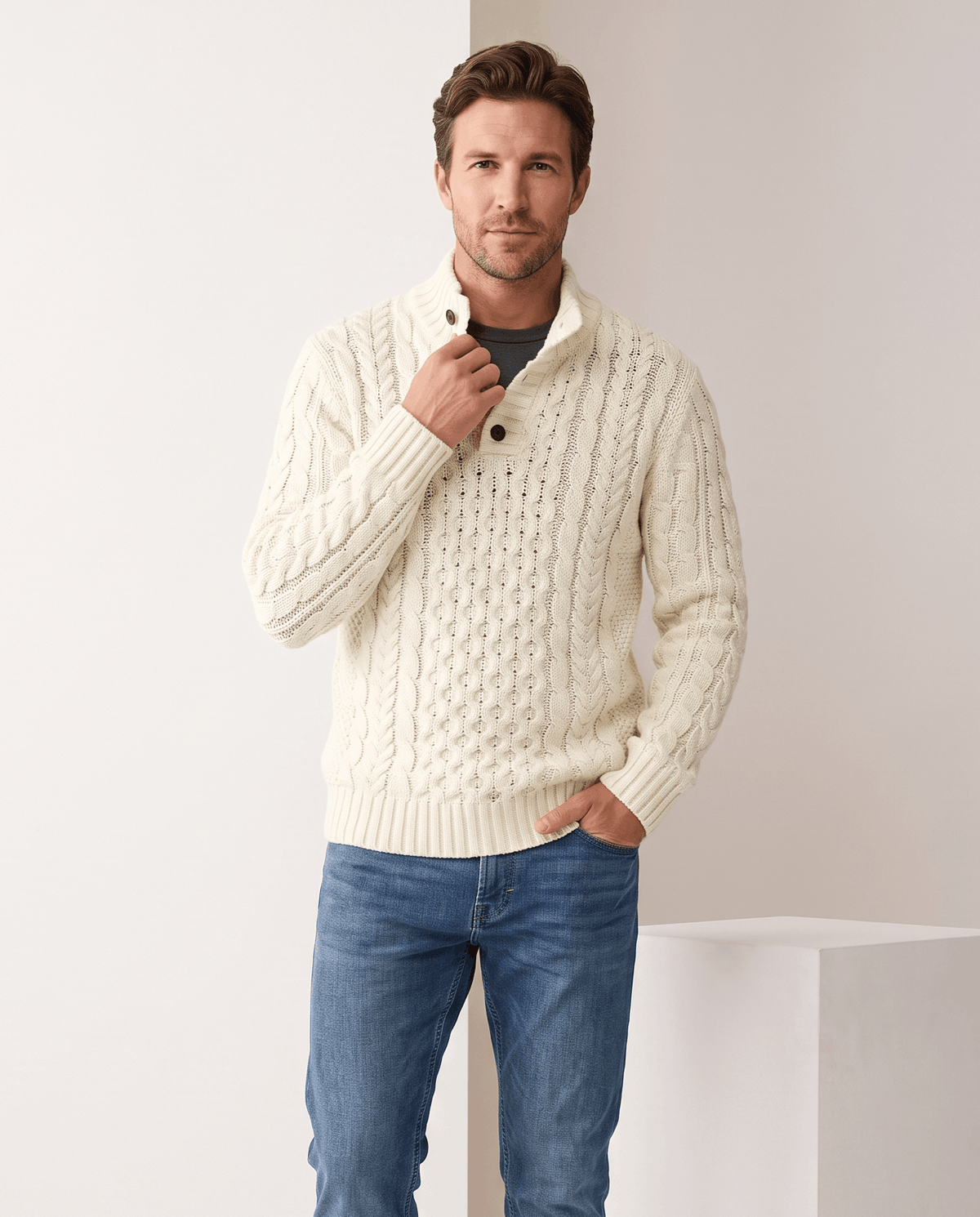 Model in cream button mock neck sweater with light blue jeans