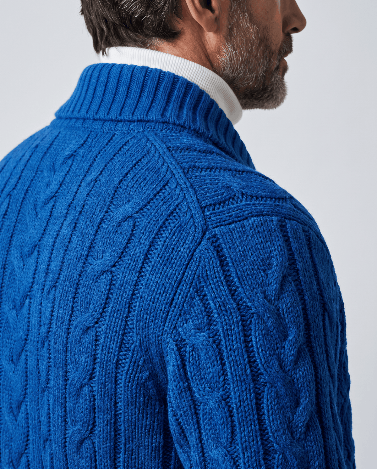 Close back view of blue cable knit cardigan collar and shoulder