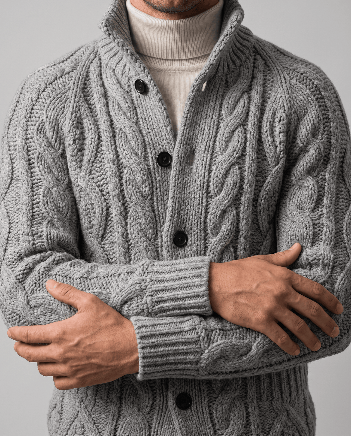 Gray cardigan with arms crossed showing cable-knit texture and ribbed cuffs