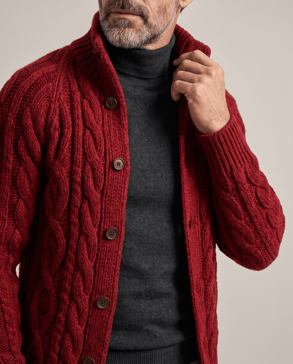 Red cable knit cardigan stand collar and buttons shown in close view