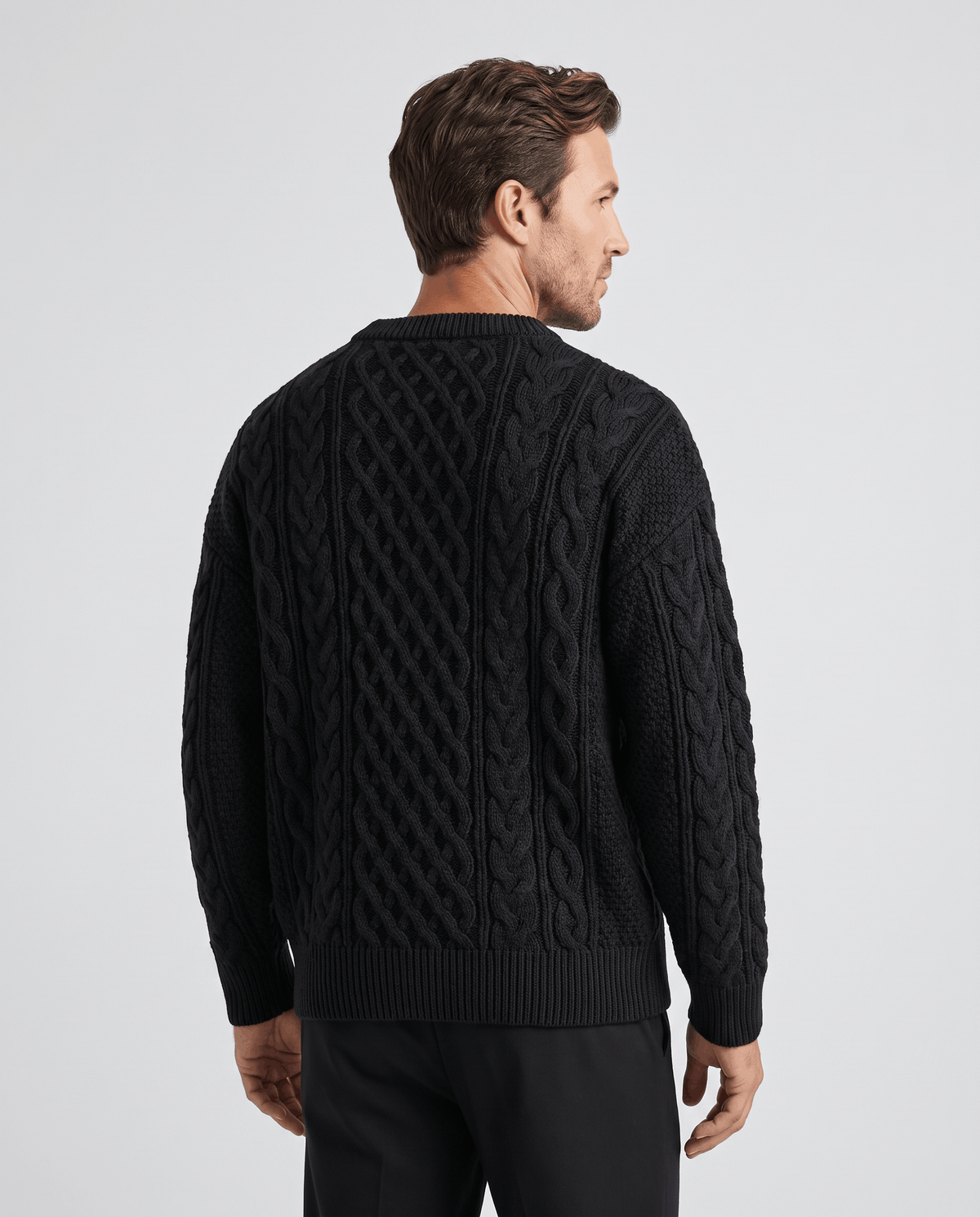 Back view of black cable pullover with ribbed collar and ribbed cuffs