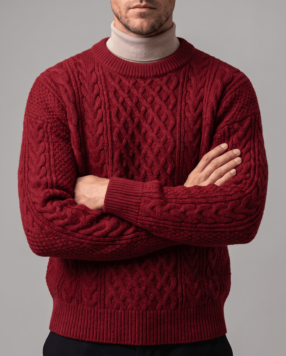 Burgundy cable sweater worn over beige mock neck with arms crossed at chest