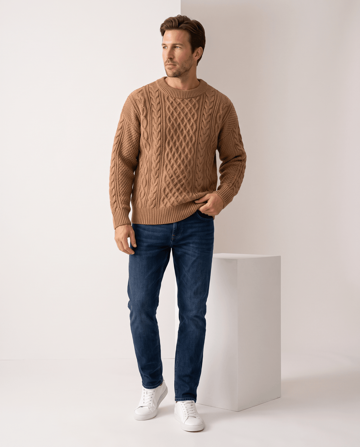 Full-length camel knit look with blue jeans and white sneakers