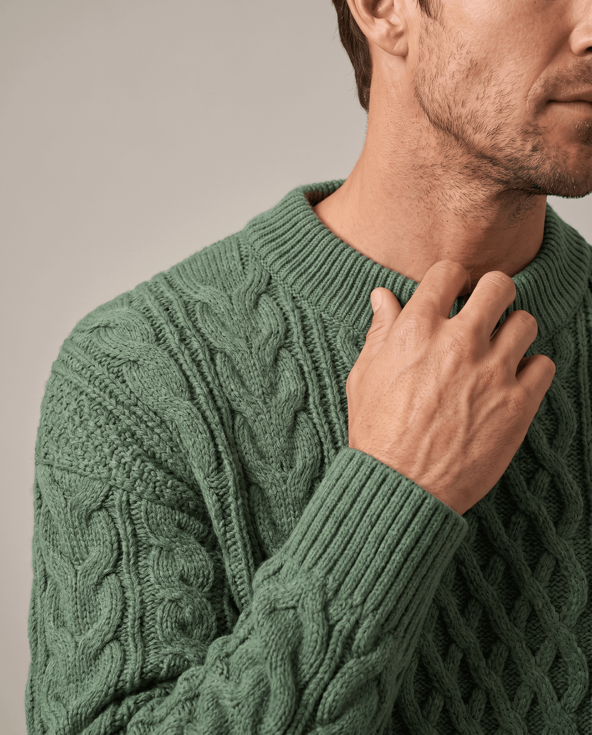Hand resting at the ribbed collar of a sage green chunky knit