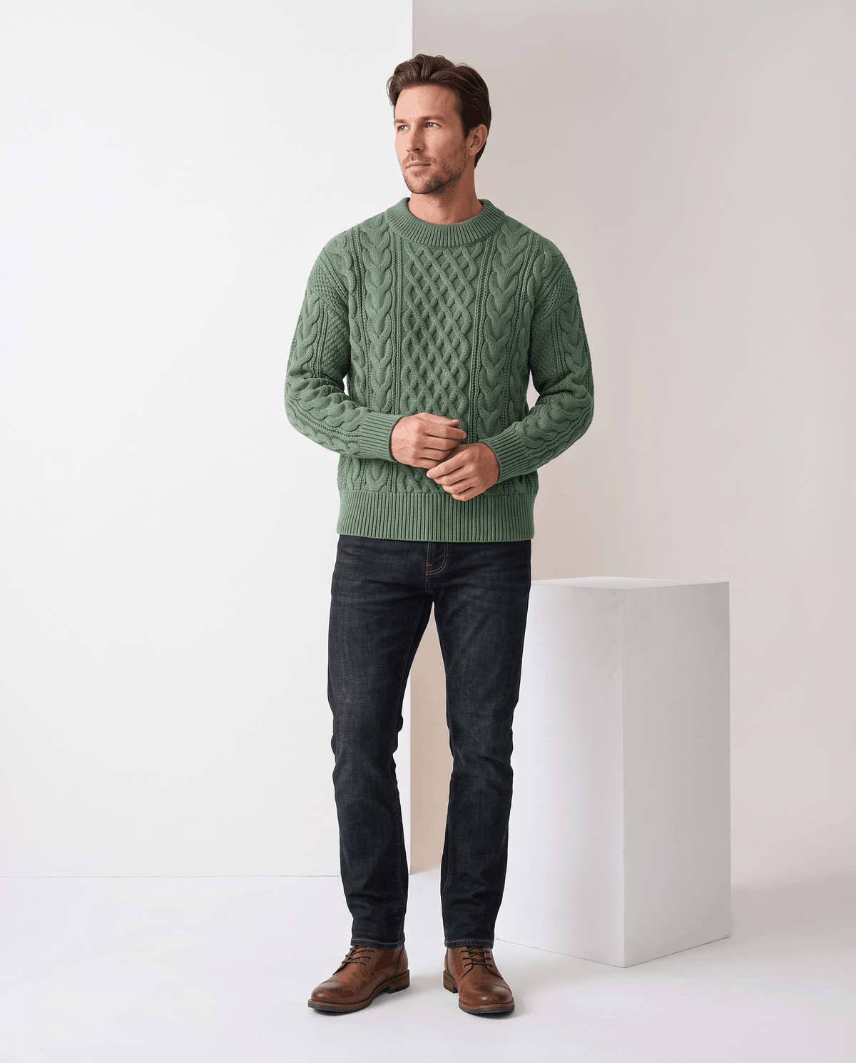Model in sage green crew neck sweater with black jeans and brown boots