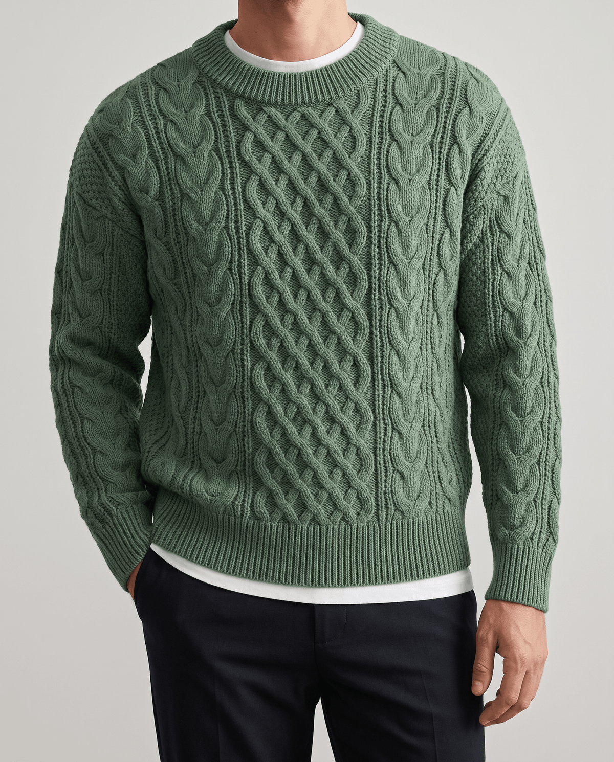 Front close-up of sage green cable sweater layered over a white tee