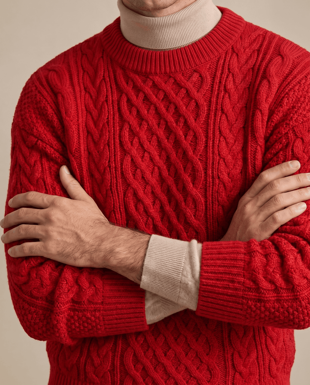 Bright red knit sleeve with rope cables and ribbed cuff over folded arms