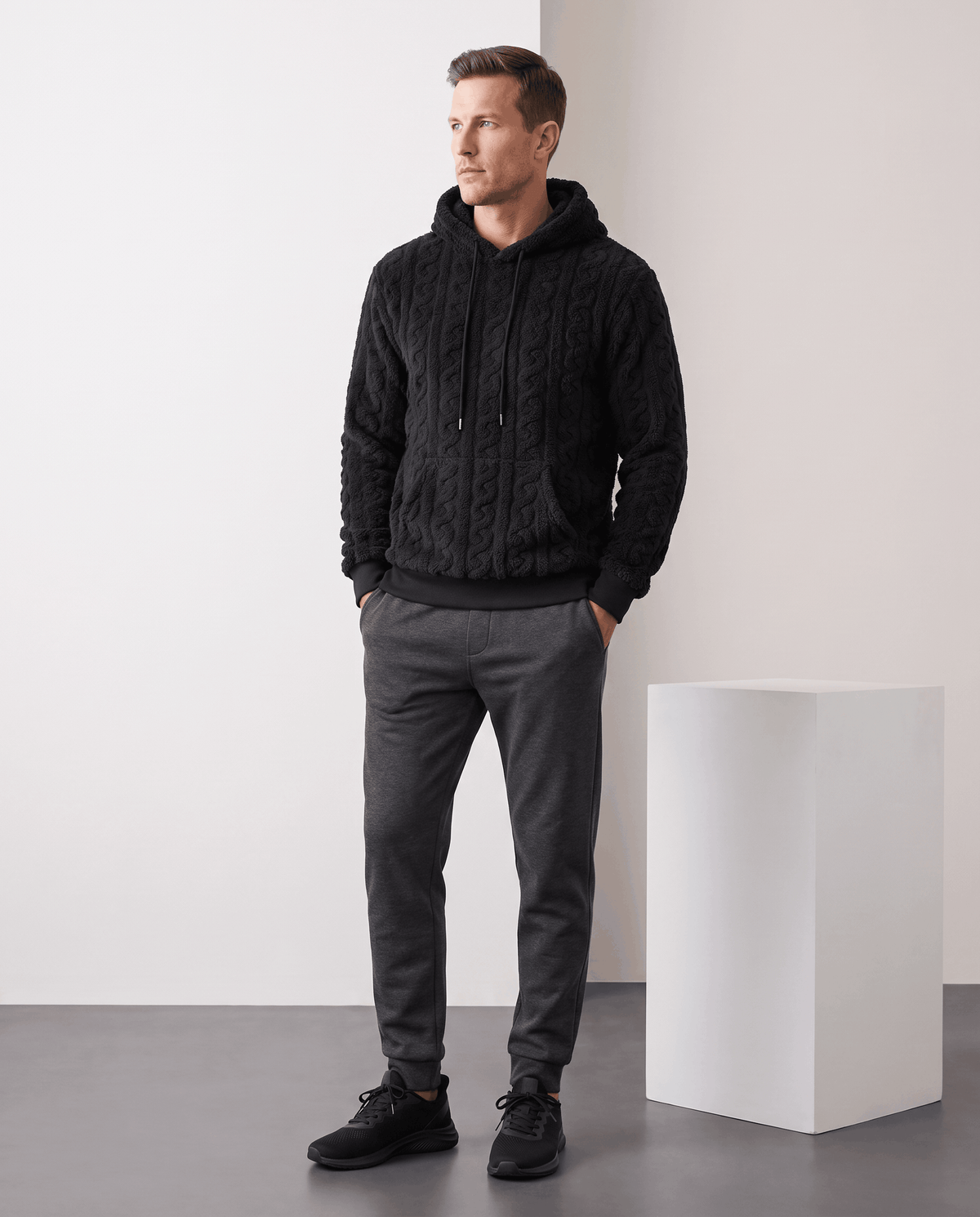 Full-length view of black hoodie styled with gray plaid pants and black shoes