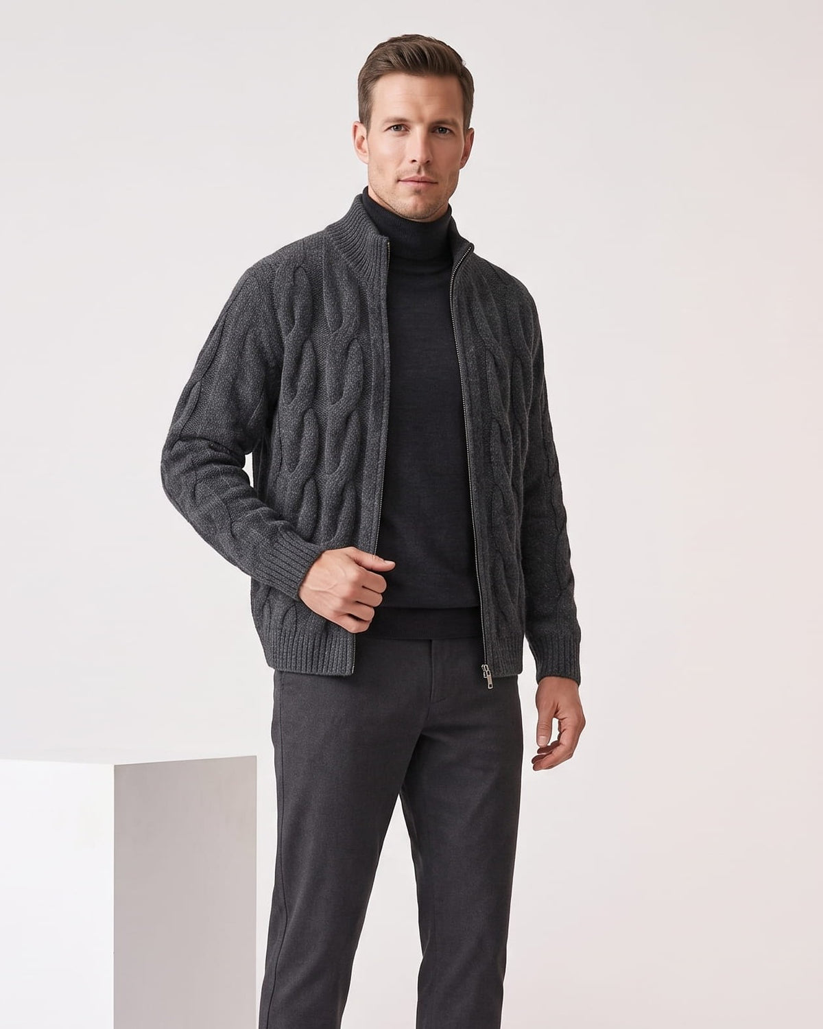 Gray cable knit zip cardigan worn open over a black turtleneck