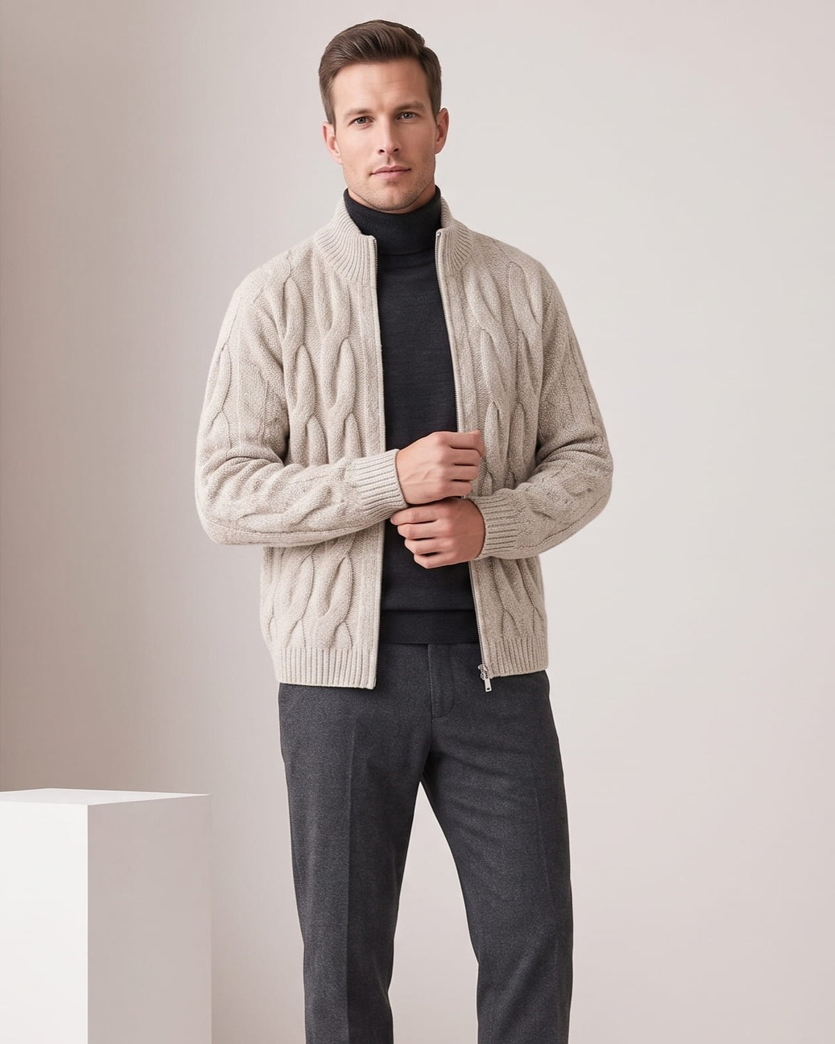 Man wearing a khaki cable knit full-zip cardigan sweater over a dark turtleneck