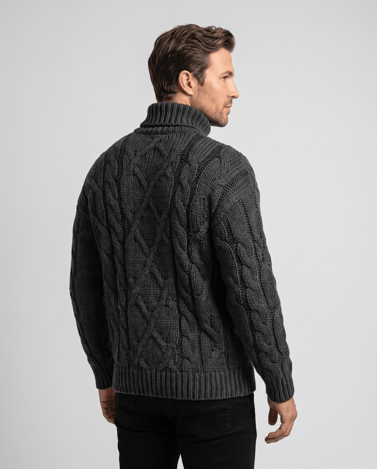 Back view of charcoal black cable sweater with ribbed turtleneck and ribbed hem