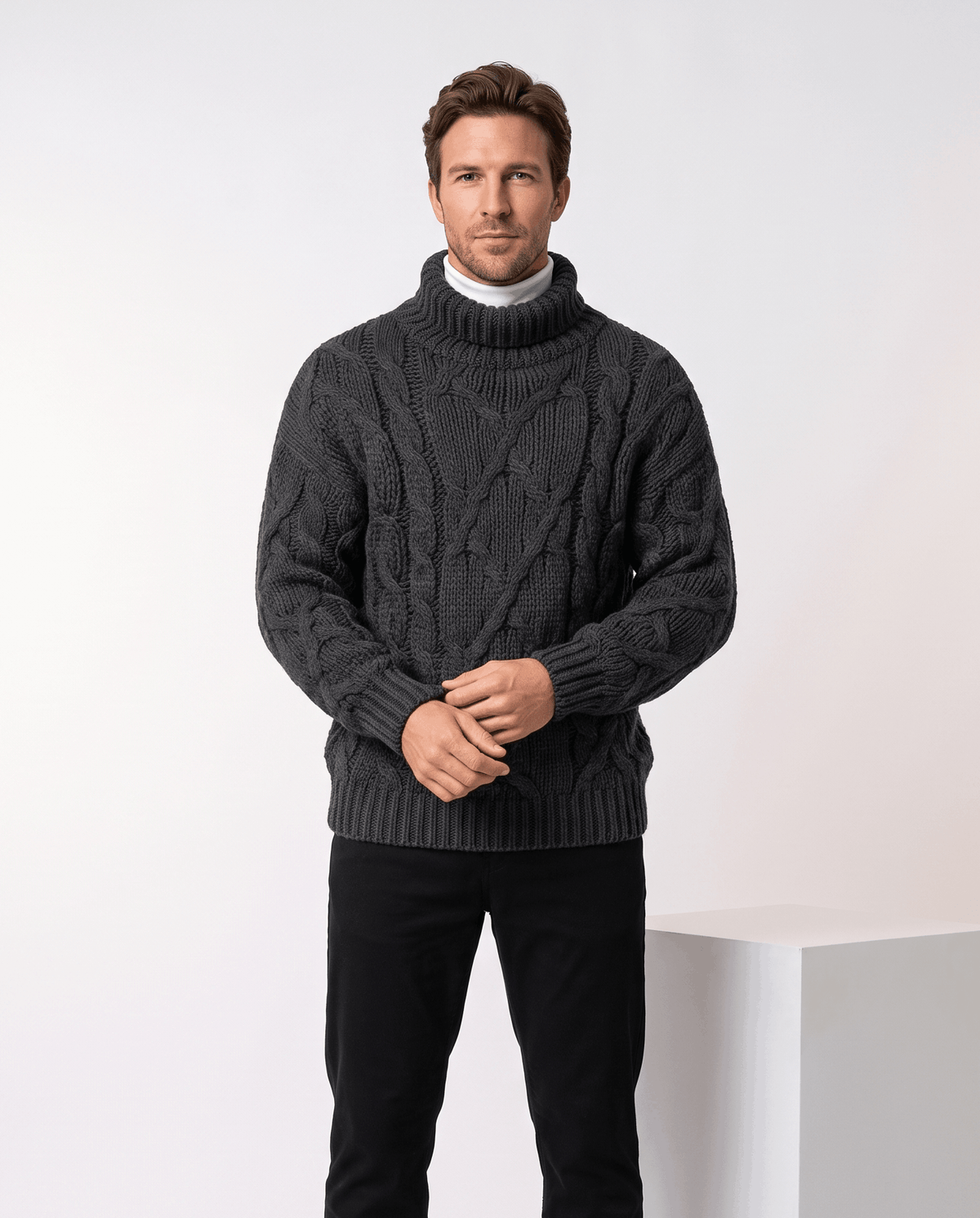 Model in charcoal black turtleneck worn over white mock neck with black trousers