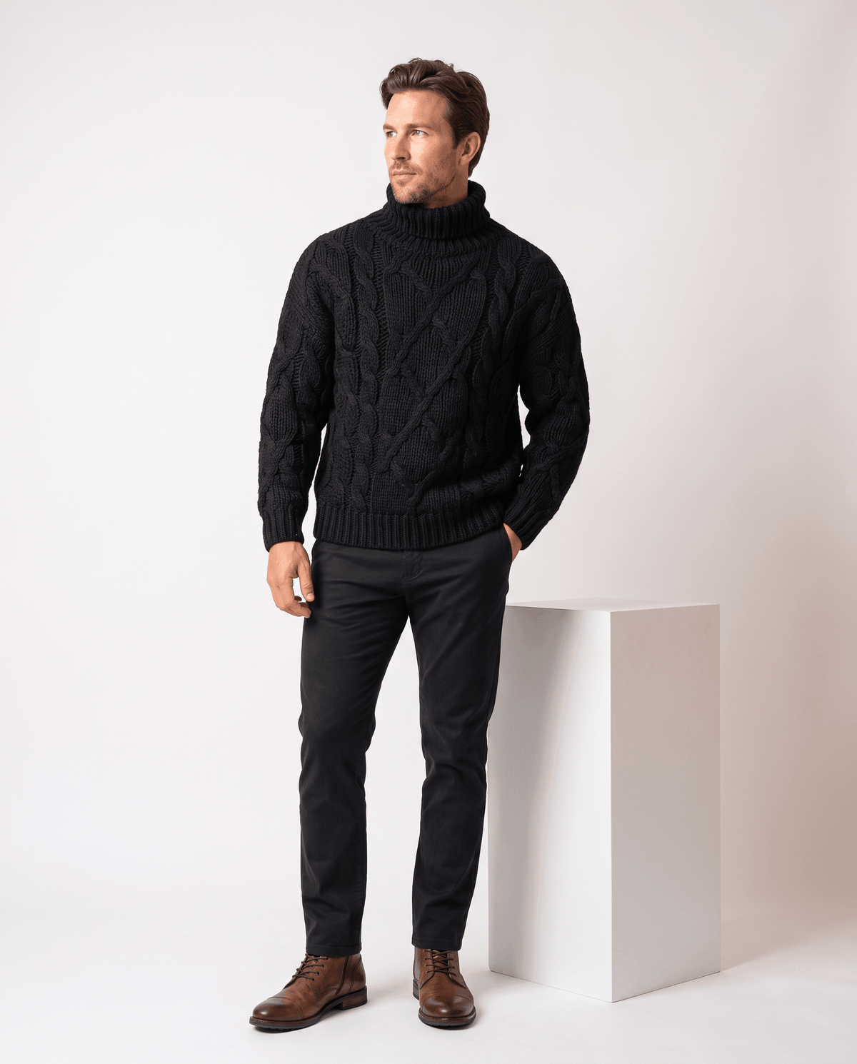 Full-length view of black turtleneck sweater with dark trousers and brown leather boots
