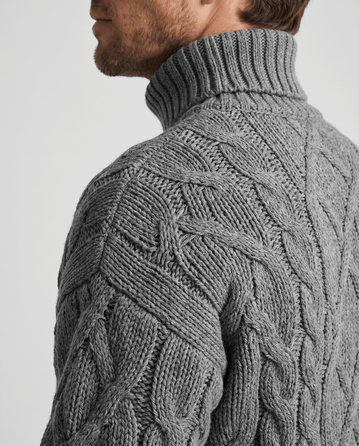 Shoulder and collar close-up of heather gray sweater showing raised cable texture