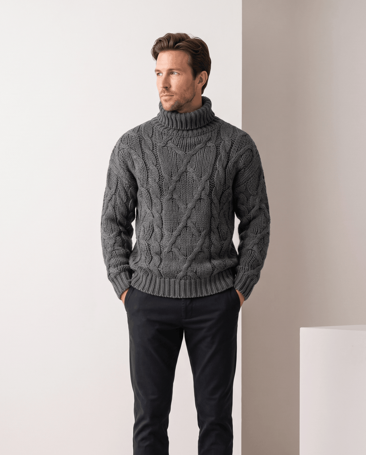 Model in heather gray turtleneck sweater with hands in pockets and black trousers