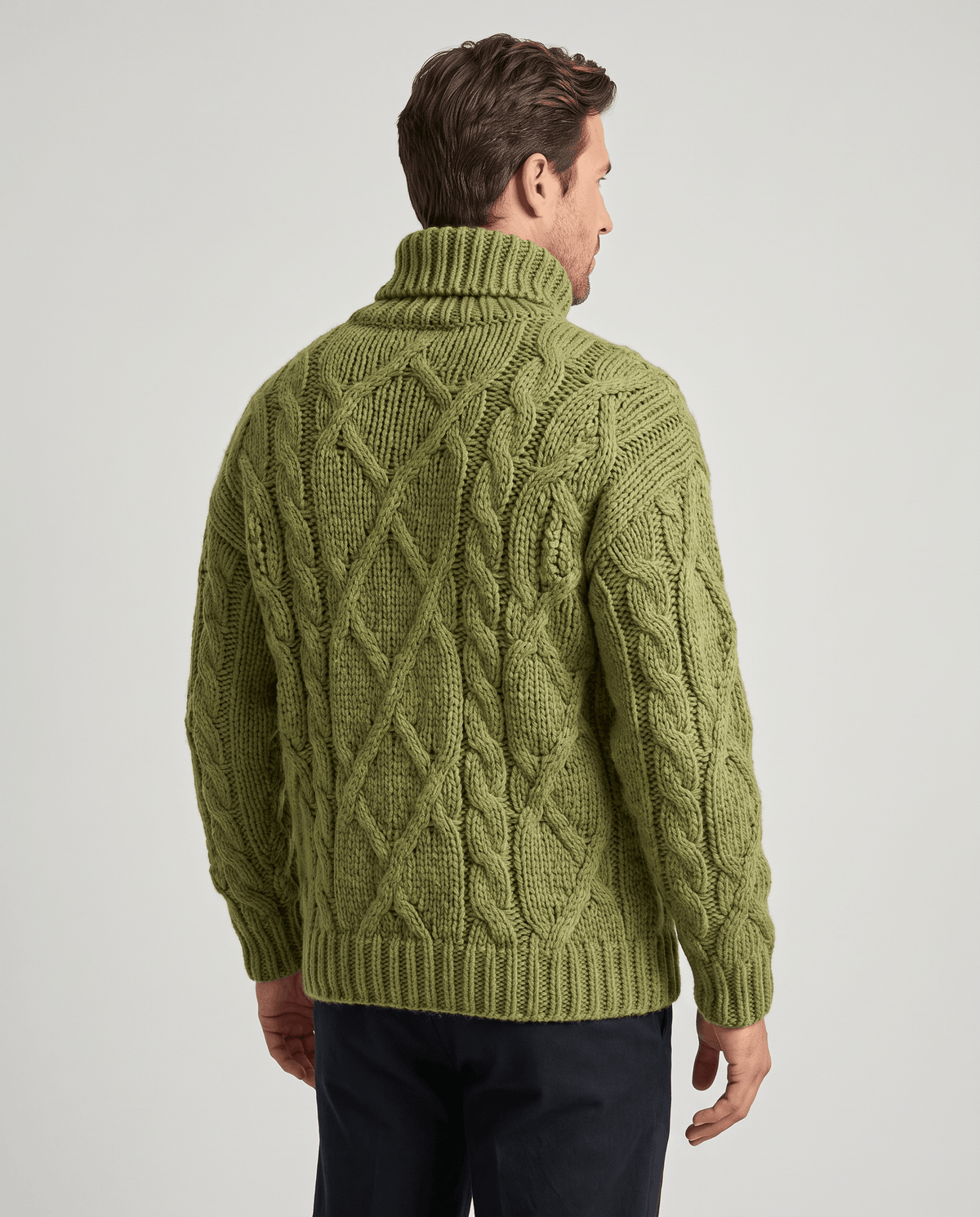 Back view of olive green knit sweater showing full cable pattern and ribbed hem