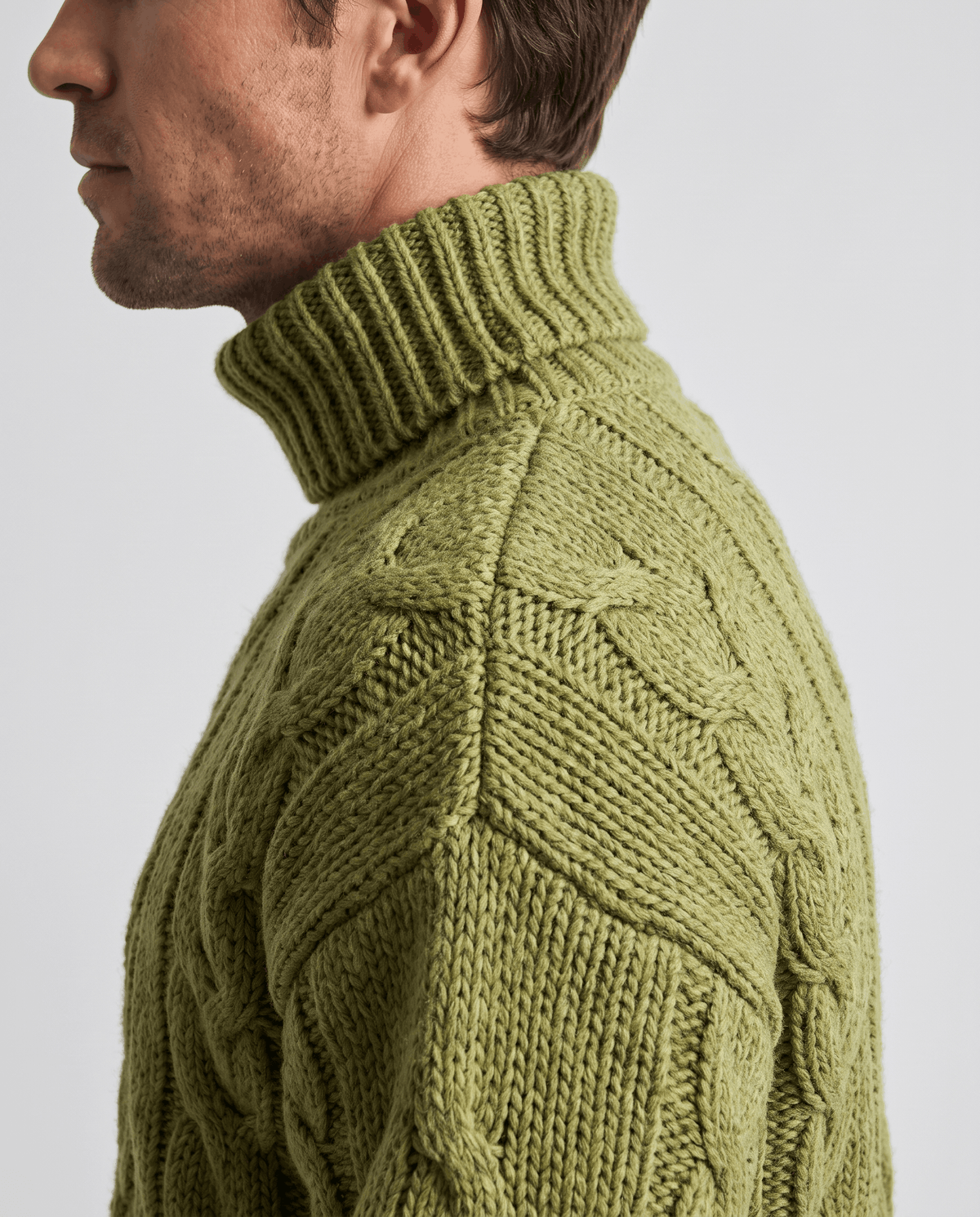 Side profile of olive green fold-over turtleneck collar and ribbed neck detail