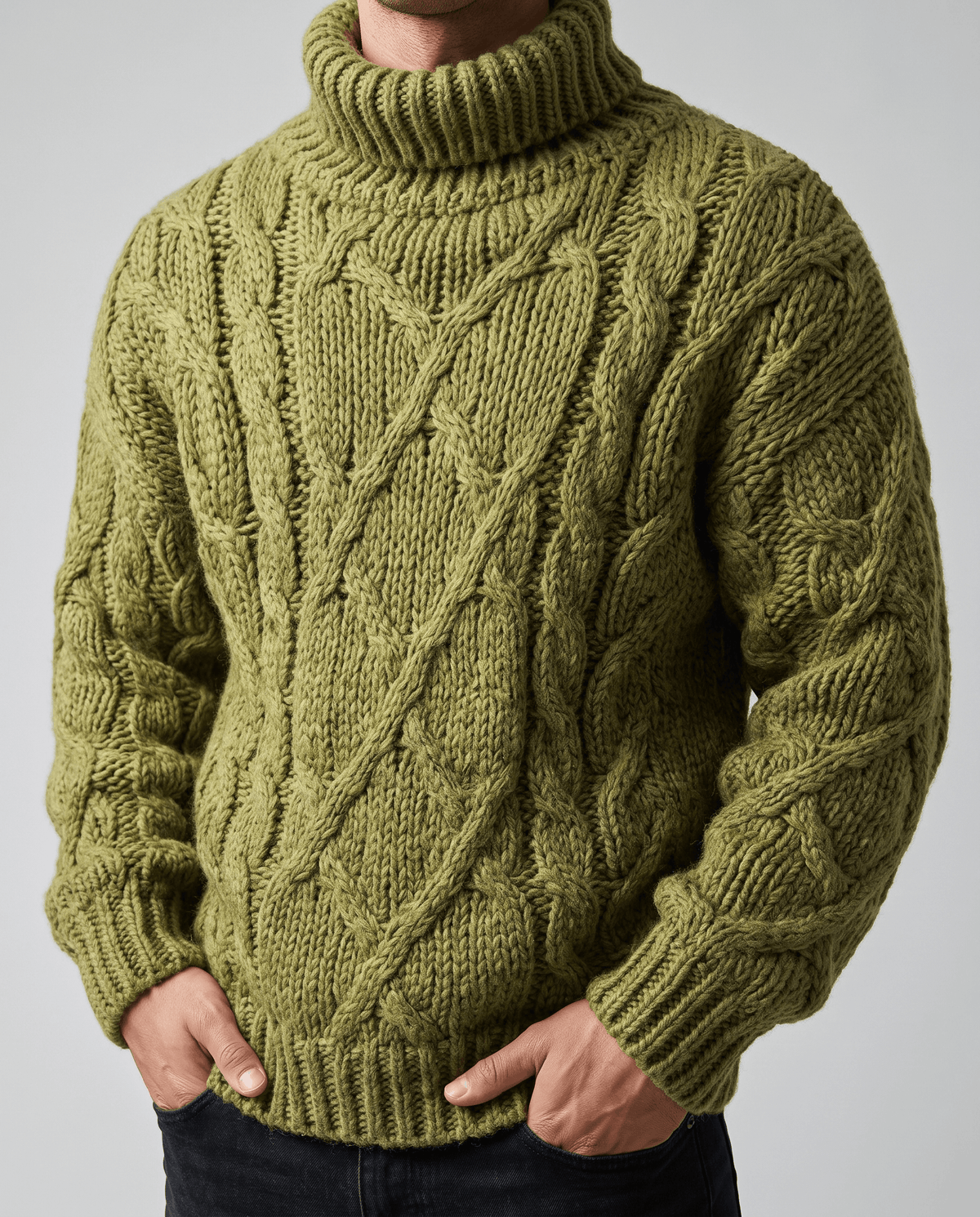 Close-up front of olive green sweater showing diamond and rope cable stitch pattern