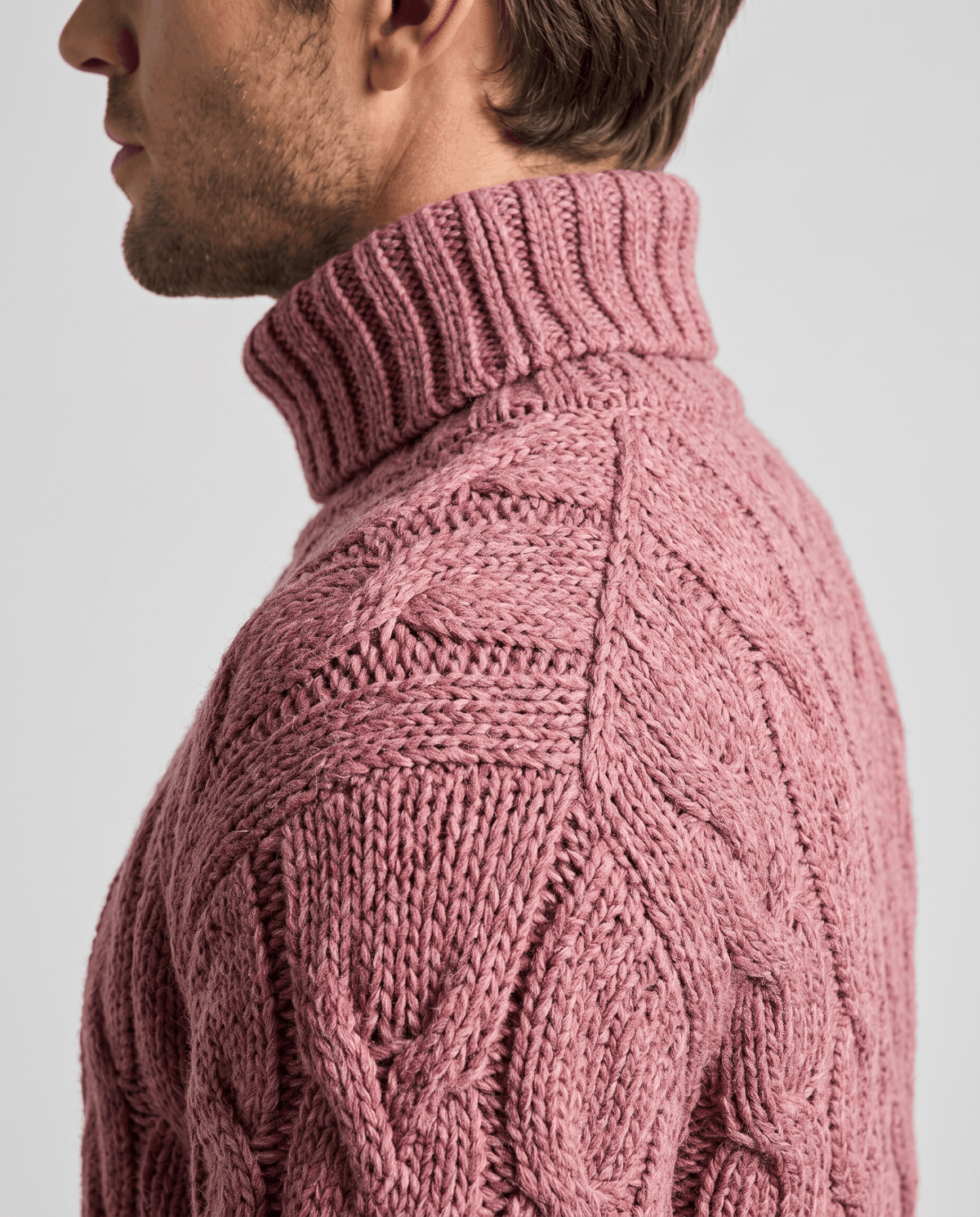 Side close-up of dusty pink fold-over collar and cable stitching on shoulder