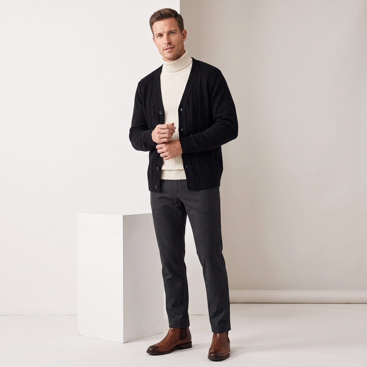 Full-length view of the black cardigan over a cream turtleneck with brown shoes