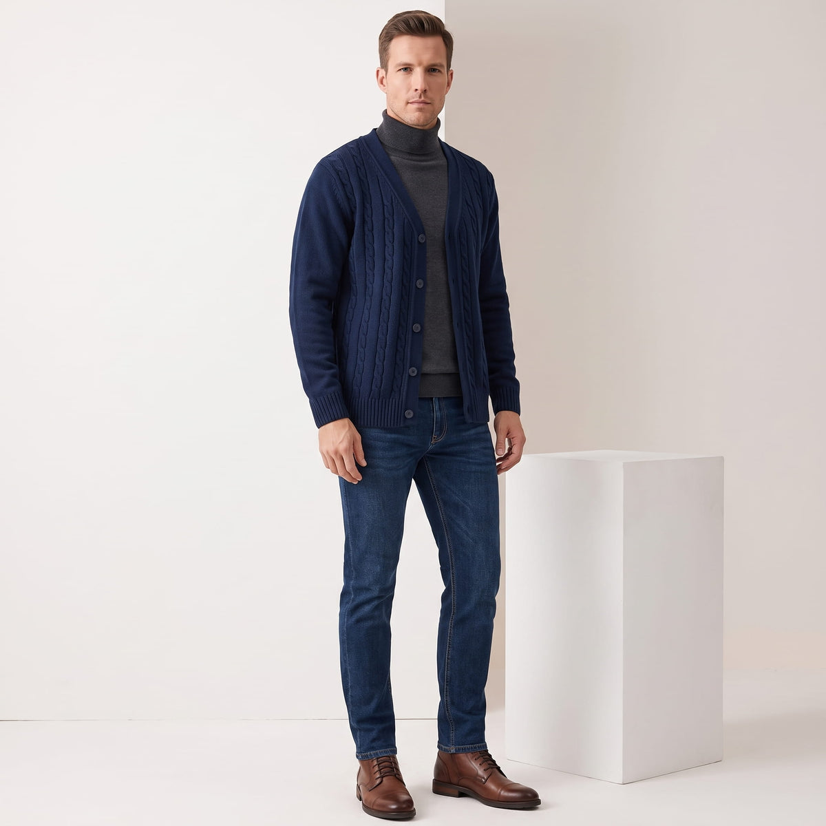 Full-length view of the navy cardigan with a gray turtleneck, jeans and brown shoes
