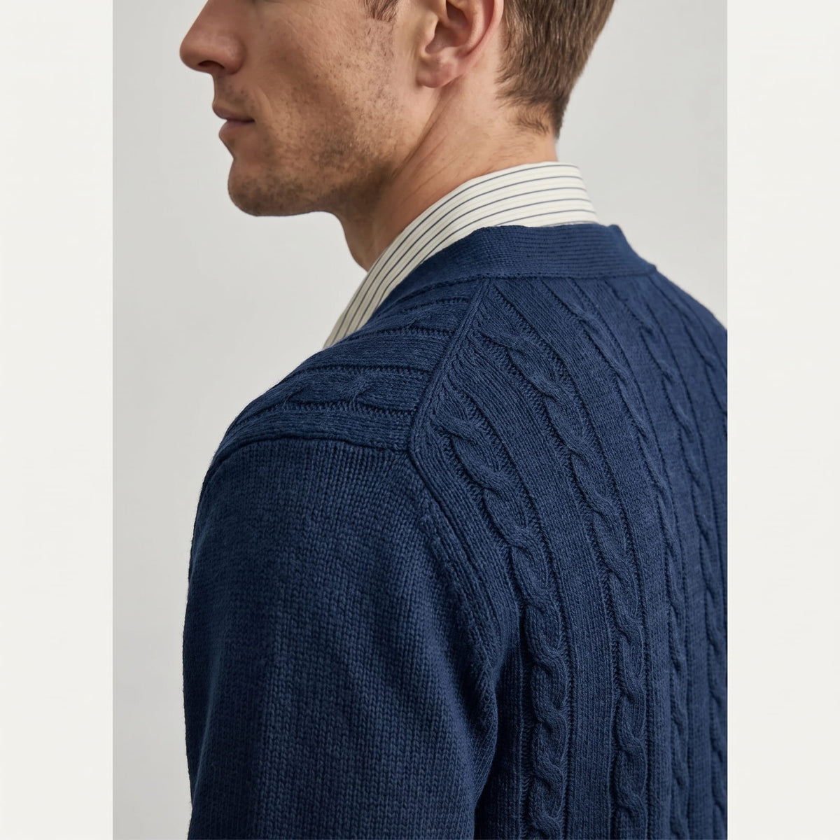 Side close-up of the navy cable knit texture at the shoulder