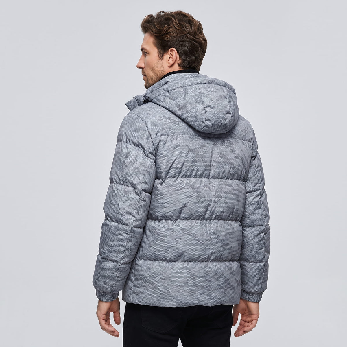 Back view of the light gray jacket showing the hood and quilted panels
