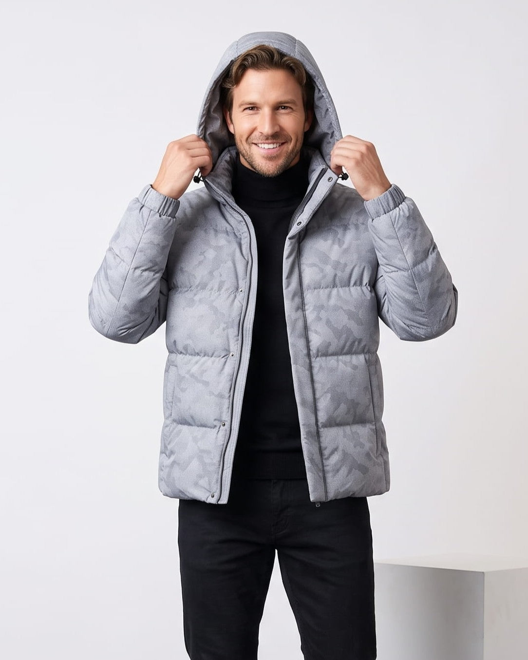 Light gray colorway worn with the hood up, hands holding the hood edges