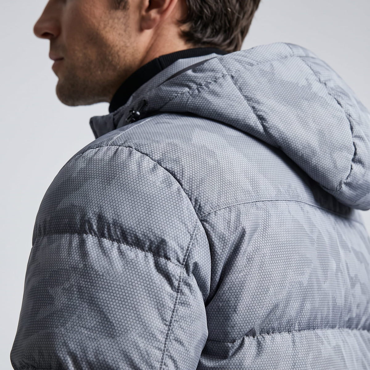 Close shoulder detail in light gray, tonal camo print across the quilting