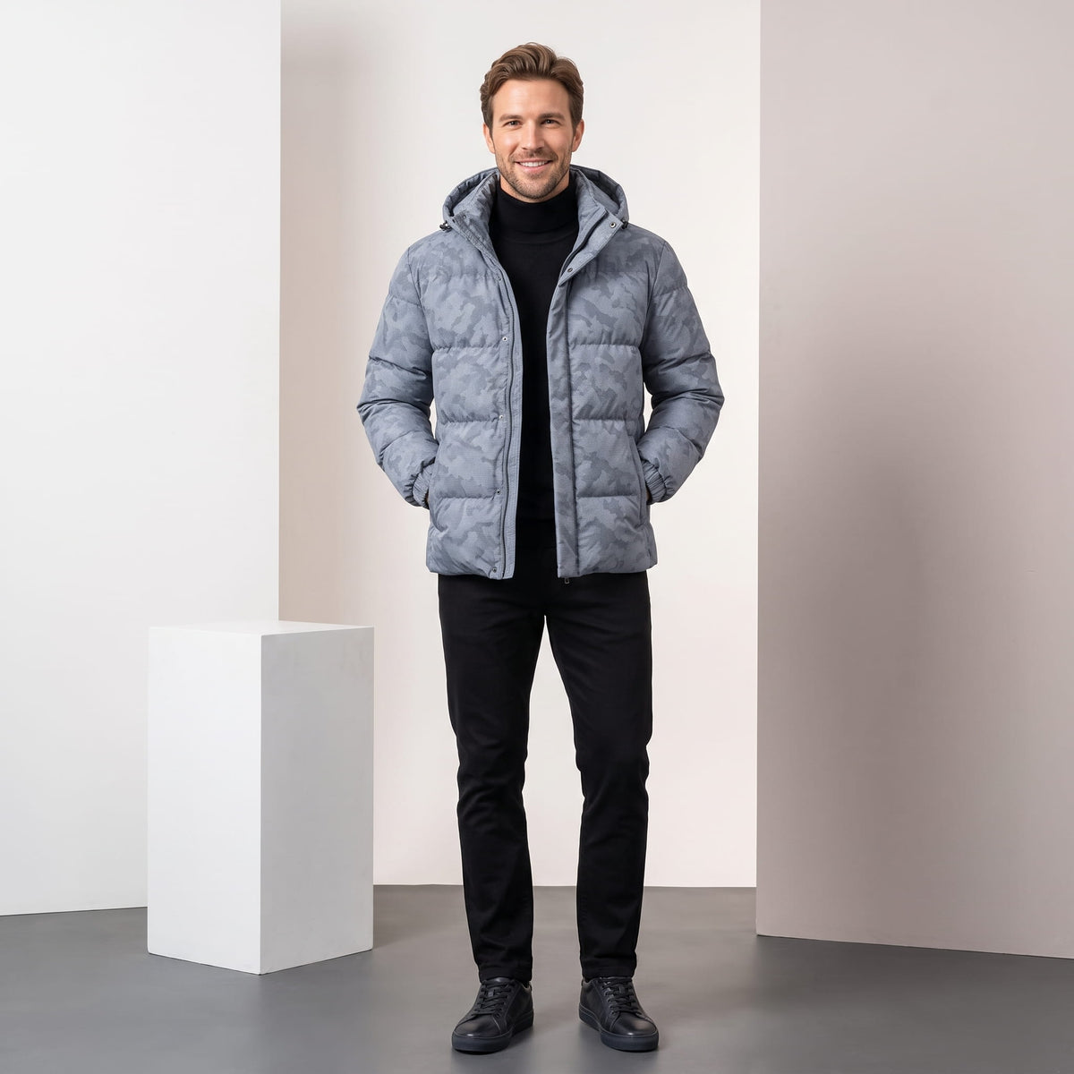 Light gray jacket styled full-length with black trousers and dark boots