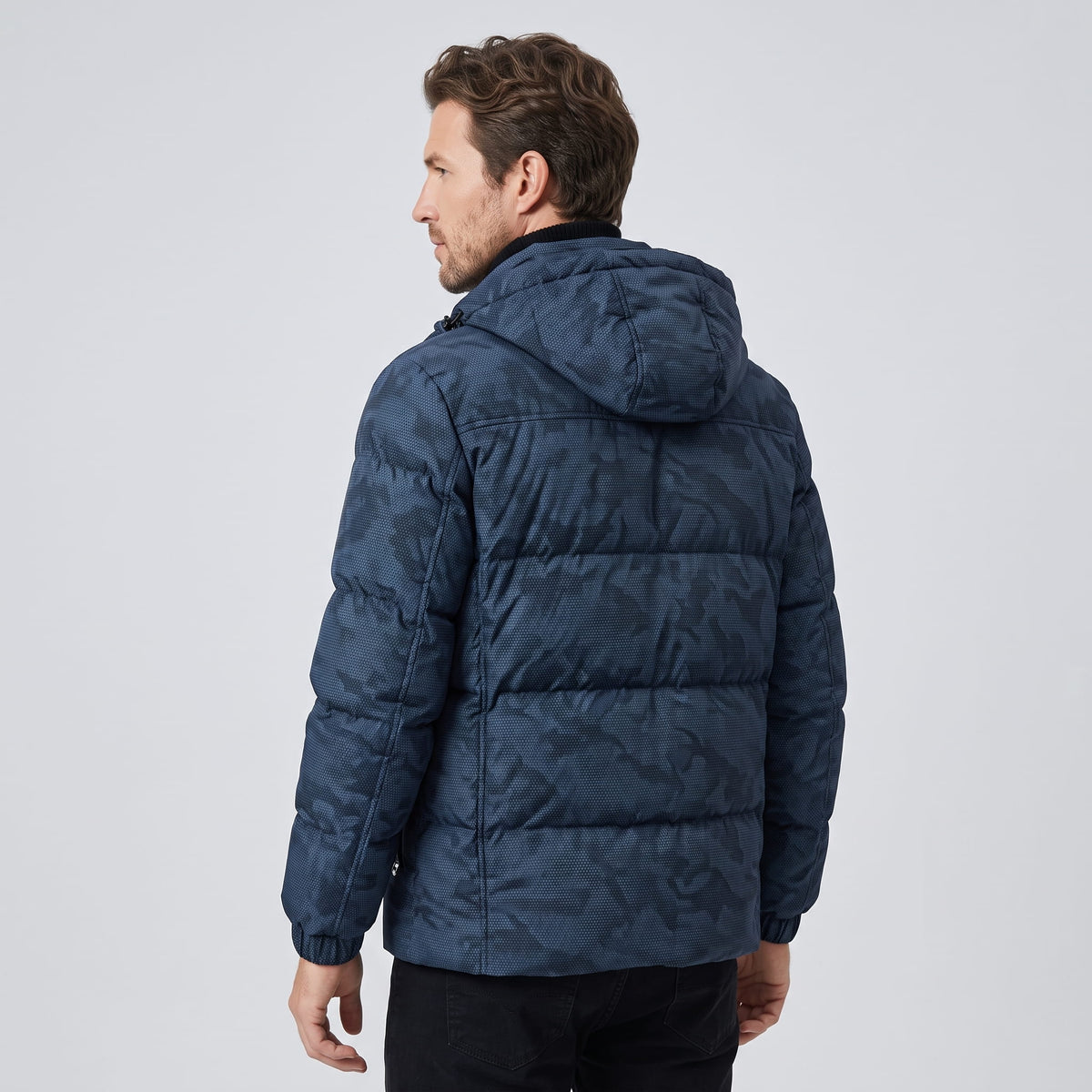 Back view of the navy jacket showing the hood and tonal camo pattern