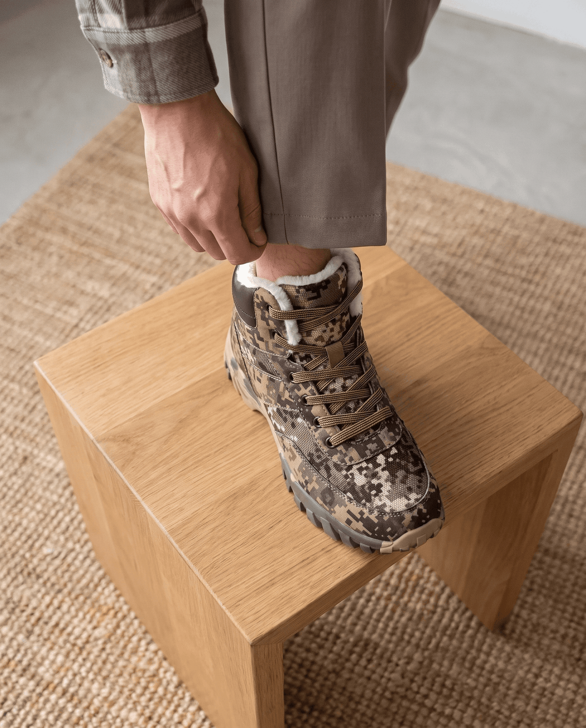 Green camo boot set on an oak bench, close on the fleece-lined collar